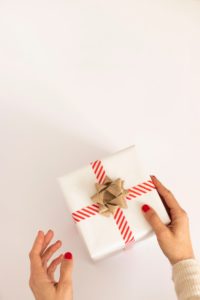 An image of woman wrapping a white paper package, symbolizing God Surprising us at Christmas